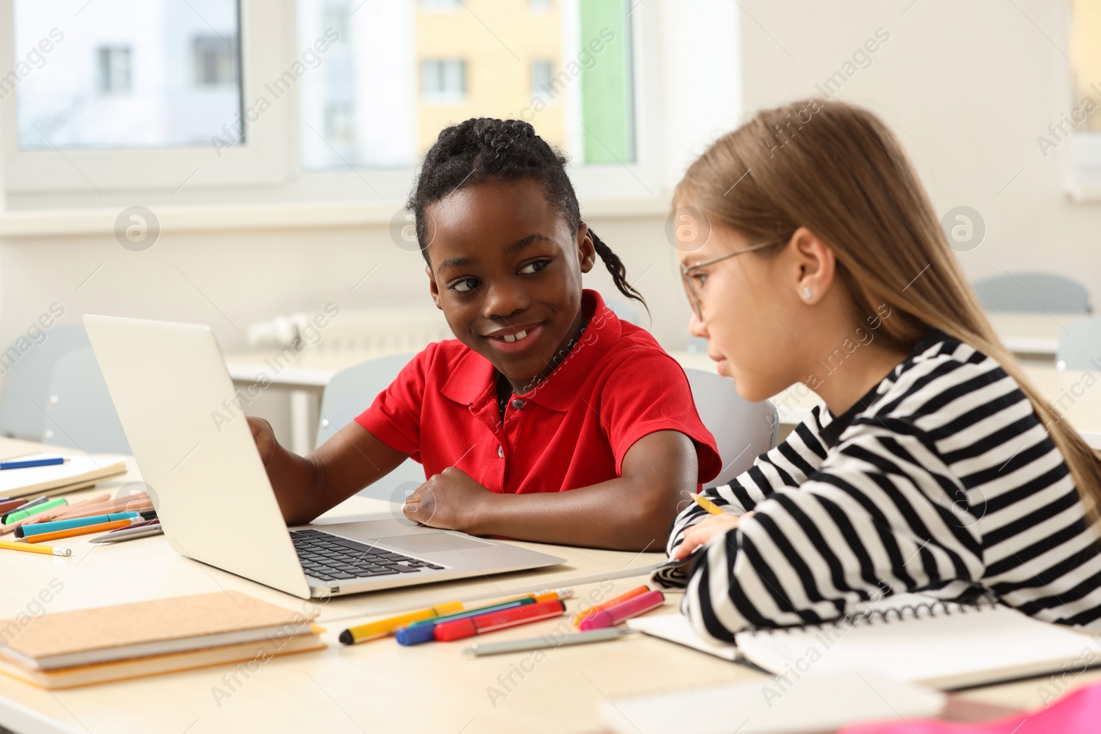 Photo of Cute children studying in classroom at school