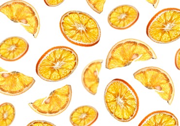 Many dry orange slices falling on white background