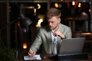 Young man working in office at night