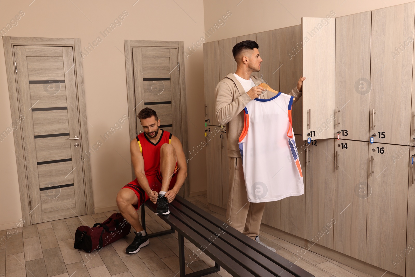 Photo of Handsome men changing clothes in locker room
