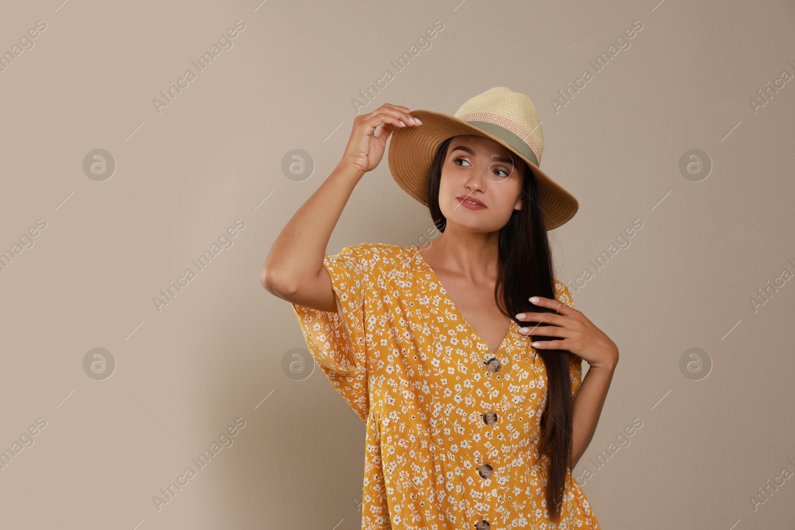 Photo of Beautiful young woman with straw hat on beige background