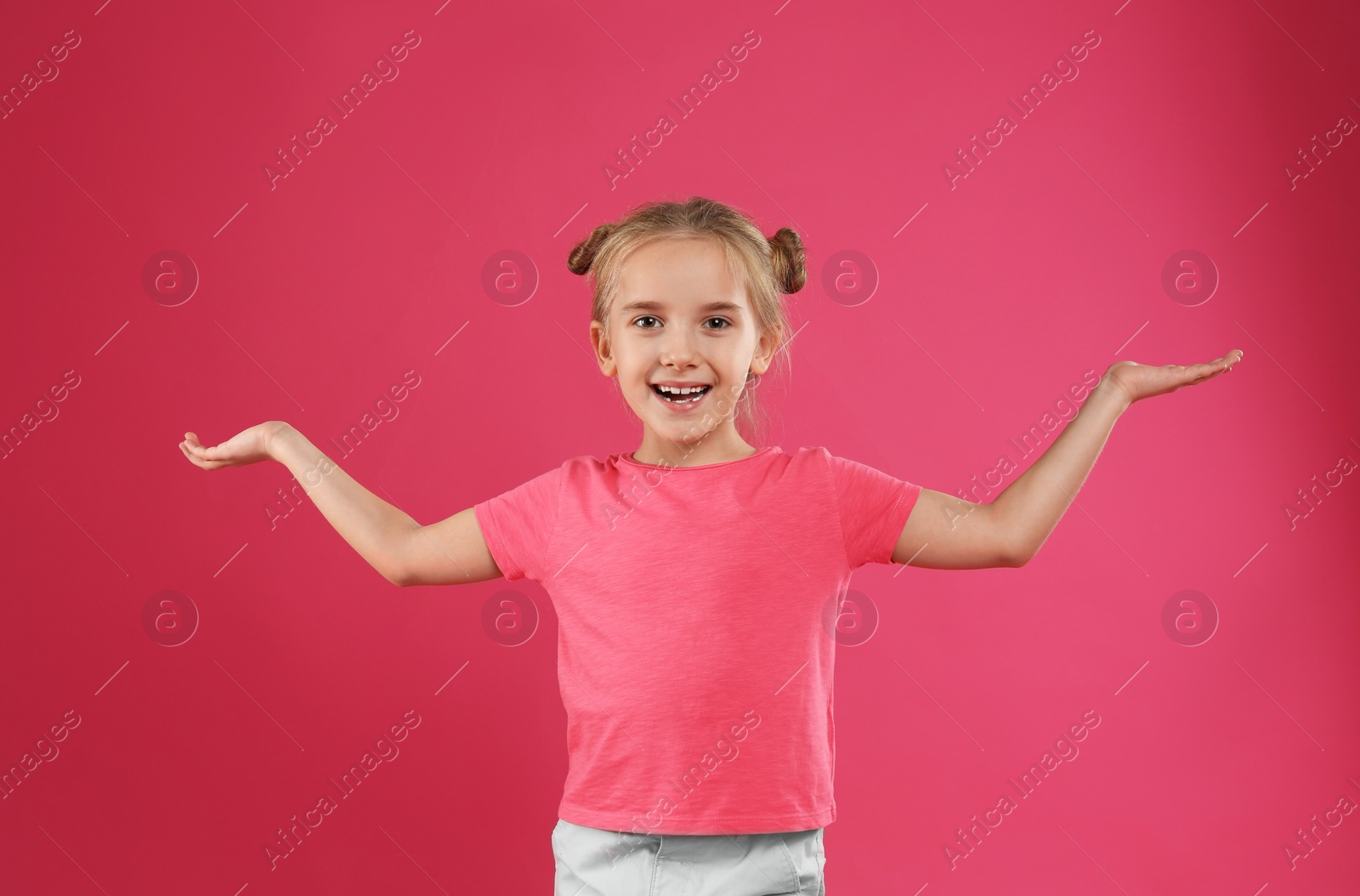 Photo of Cute little girl posing on pink background