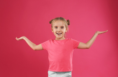 Cute little girl posing on pink background