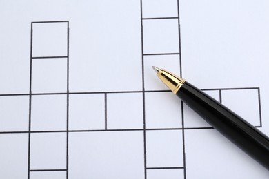 Photo of Pen on blank crossword, top view. Space for text