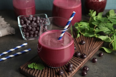 Photo of Composition with glass of acai juice and fresh berries on dark table