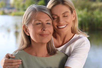 Photo of Family portrait of happy mother and daughter outdoors