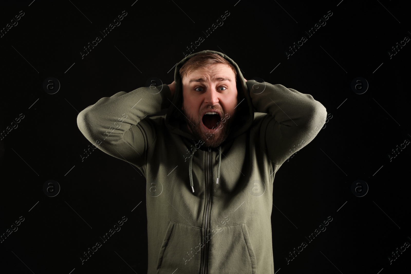 Photo of Portrait of emotional young man on black background. Personality concept