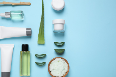 Flat lay composition with aloe vera and cosmetic products on light blue background. Space for text