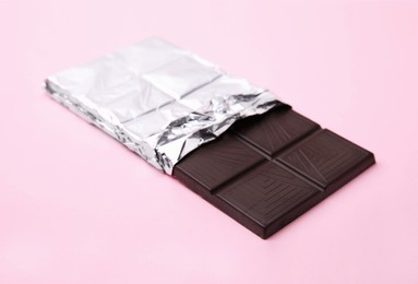 Photo of One tasty chocolate bar on pink background