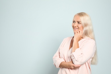 Portrait of mature woman with beautiful face on grey background. Space for text