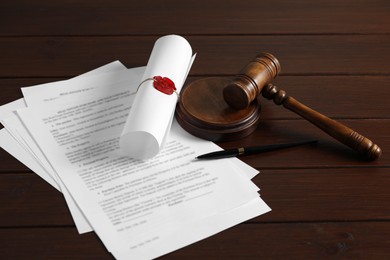 Photo of Notary contract. Documents, gavel and pen on wooden table