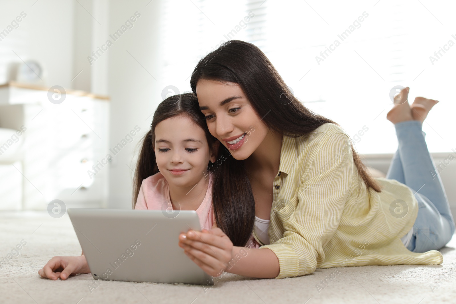 Photo of Mother and daughter reading E-book together at home