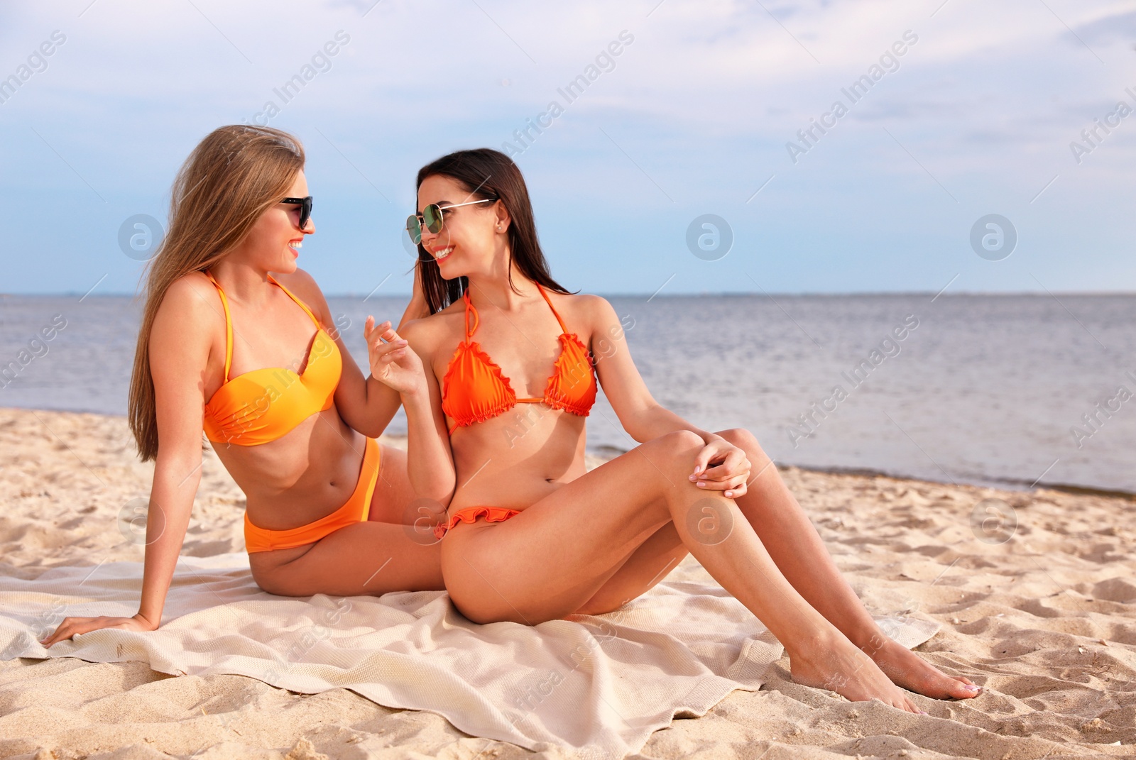 Photo of Young couple in bikini spending time together on beach