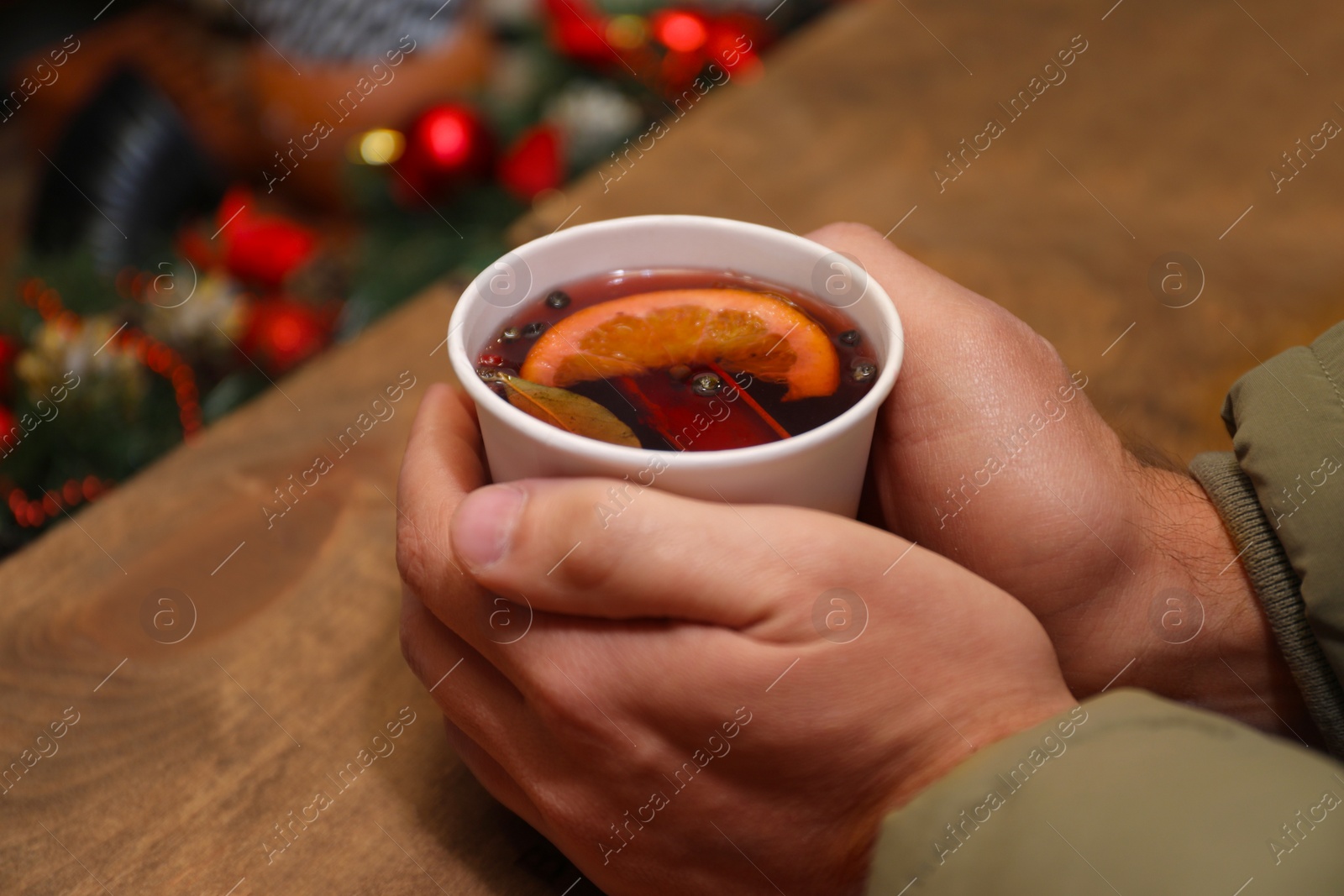 Photo of Man with cup of mulled wine at counter, closeup