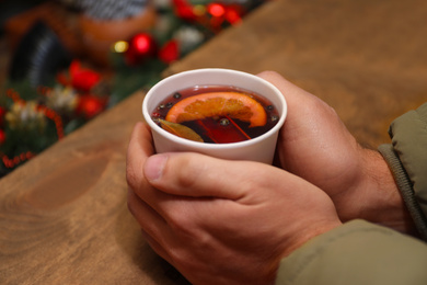 Photo of Man with cup of mulled wine at counter, closeup