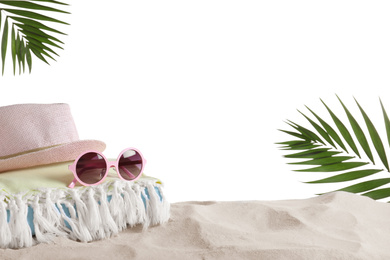 Photo of Folded towel, hat and sunglasses on sand against white background, space for text. Beach objects