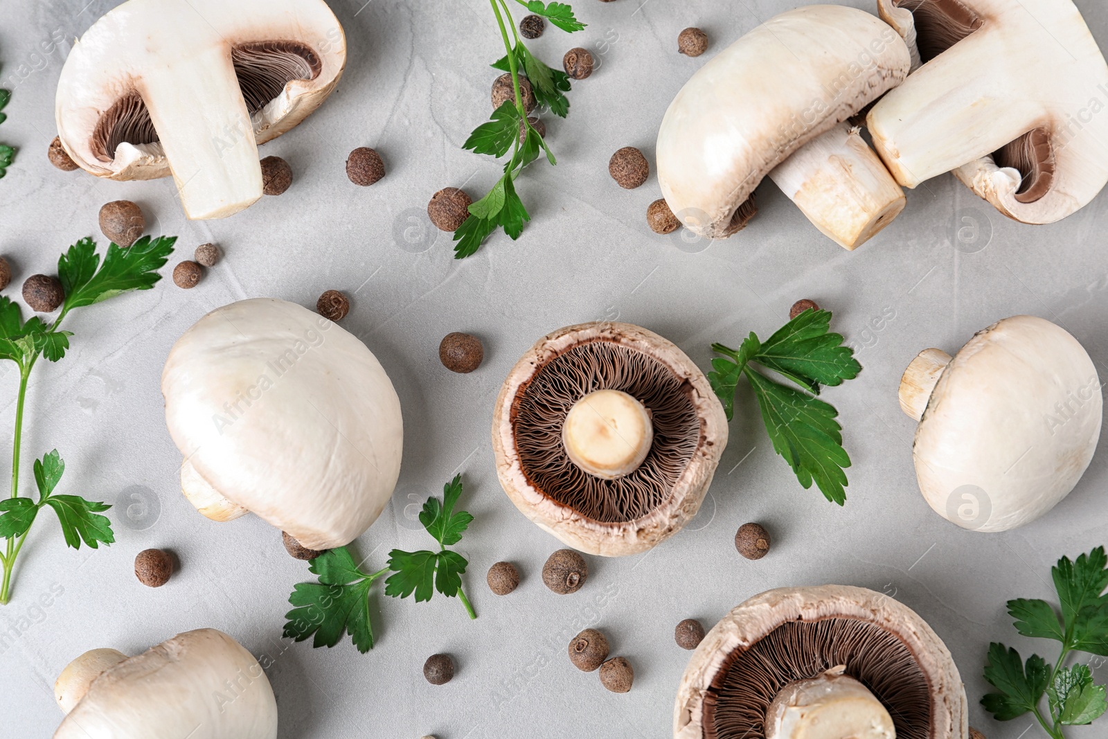 Photo of Flat lay composition with fresh champignon mushrooms on grey background