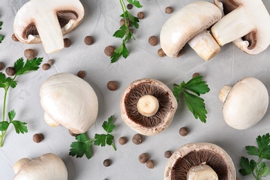 Flat lay composition with fresh champignon mushrooms on grey background