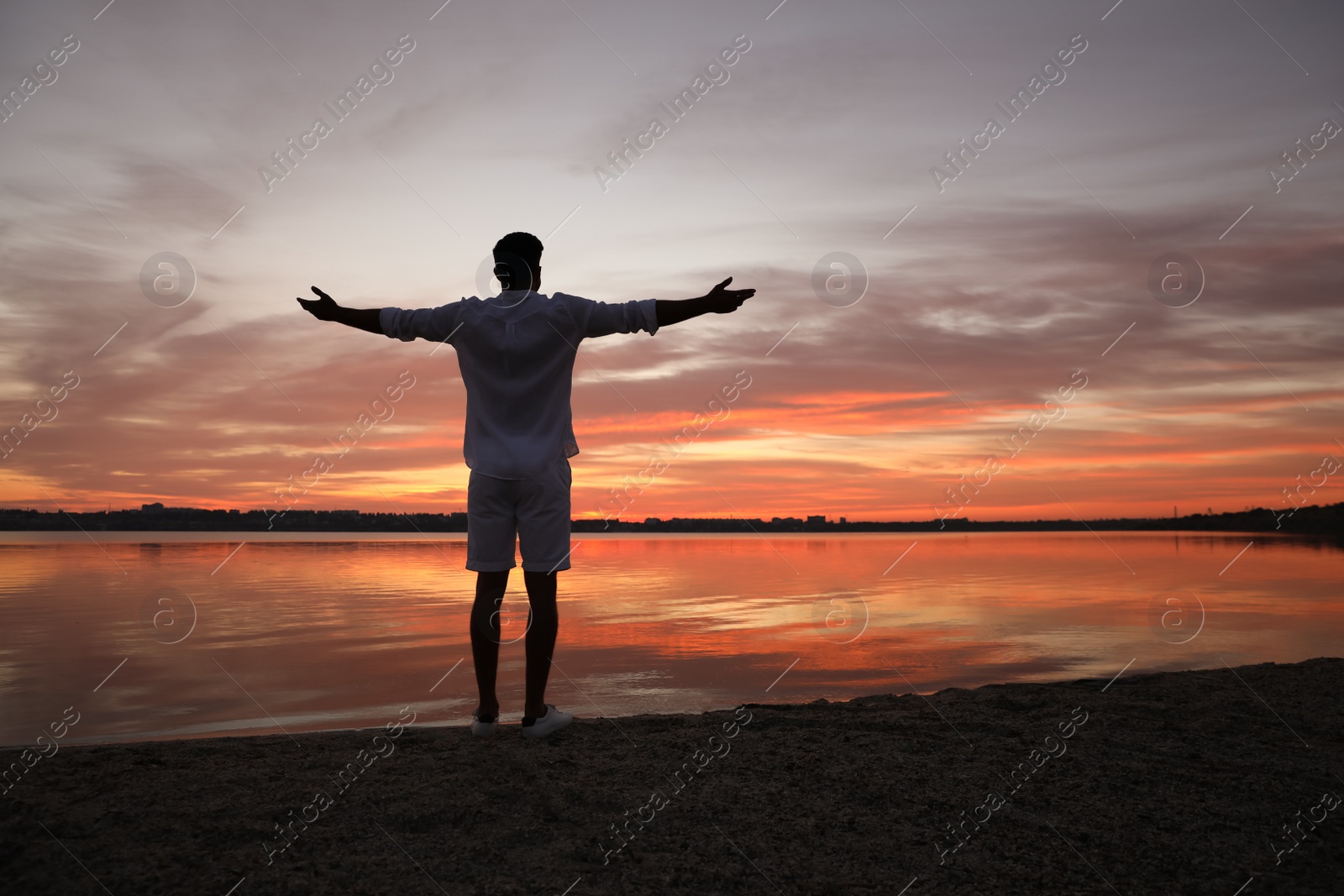 Photo of Man near river at sunset, back view. Nature healing power