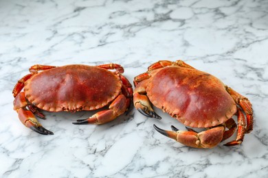 Photo of Delicious boiled crabs on white marble table