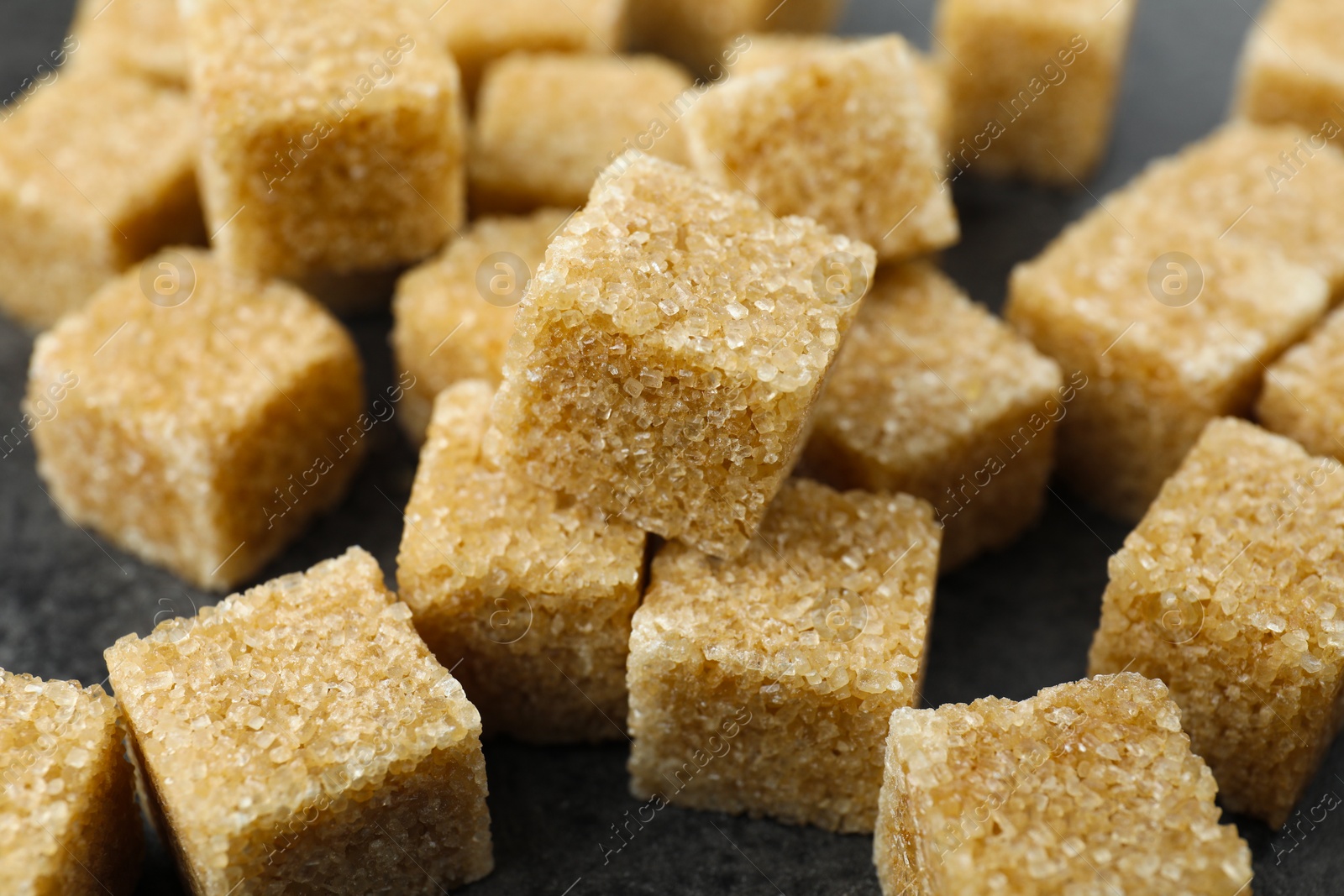 Photo of Brown sugar cubes on table, closeup view