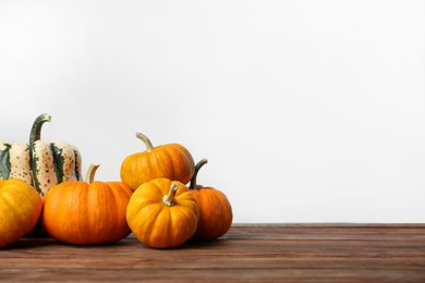 Photo of Thanksgiving day. Many different pumpkins on wooden table, space for text