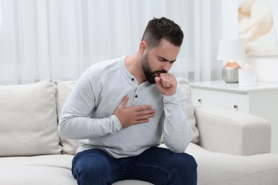 Photo of Sick man coughing at home. Cold symptoms