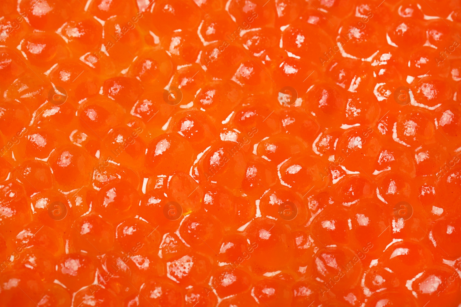 Photo of Pile of delicious red caviar as background, closeup