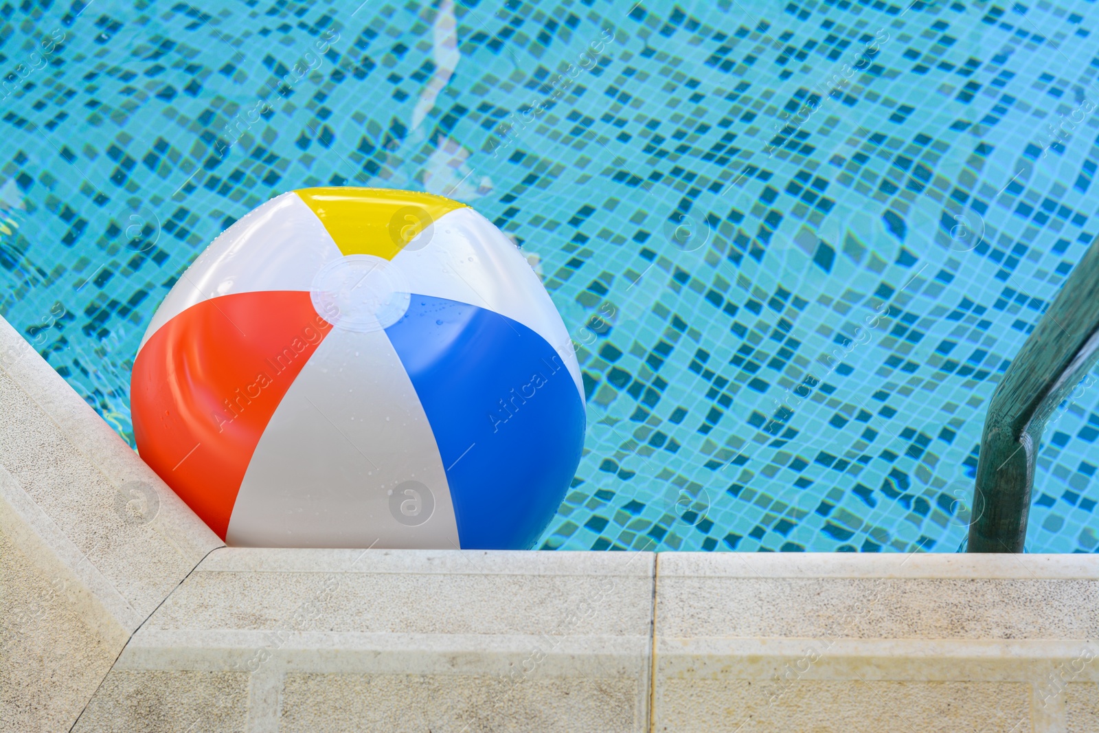 Photo of Inflatable beach ball floating in swimming pool, space for text