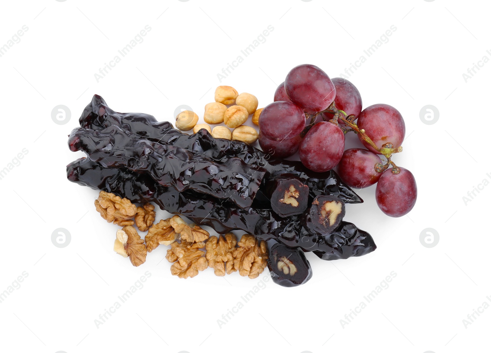 Photo of Delicious sweet churchkhelas with nuts and grapes isolated on white, top view
