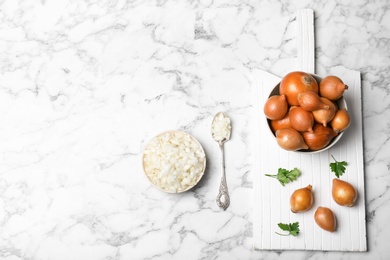 Photo of Flat lay composition with fresh ripe onions on marble table