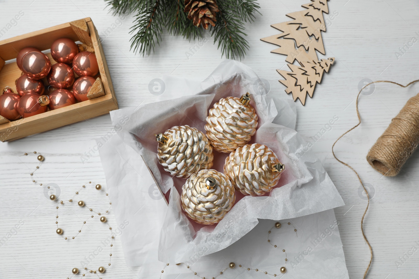 Photo of Flat lay composition with beautiful Christmas baubles on white wooden table