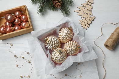 Flat lay composition with beautiful Christmas baubles on white wooden table