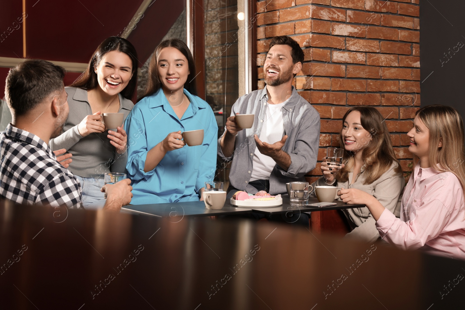 Photo of Friends with coffee spending time together in cafe