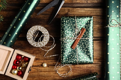 Photo of Flat lay composition with beautifully wrapped gift box on wooden table