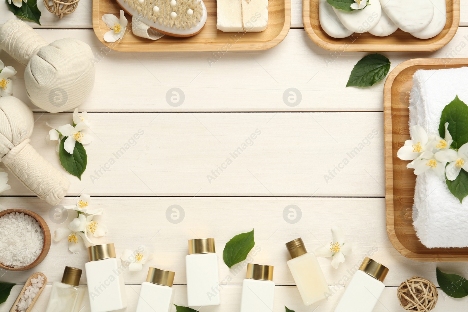 Photo of Jasmine flowers and set of spa essentials on white wooden table, flat lay. Space for text