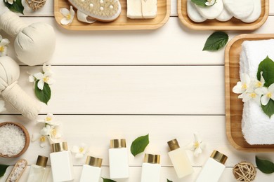 Photo of Jasmine flowers and set of spa essentials on white wooden table, flat lay. Space for text