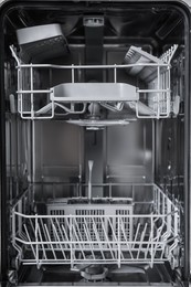 Photo of Open clean empty dishwasher, closeup. Home appliance