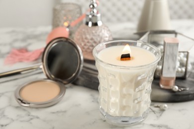 Photo of Composition with burning soy candle on white marble table, space for text