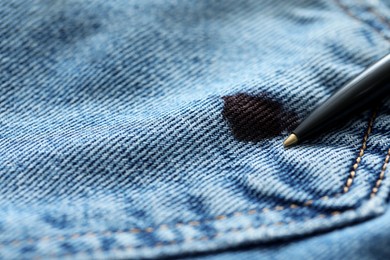Photo of Pen and stain of black ink on jeans, closeup. Space for text