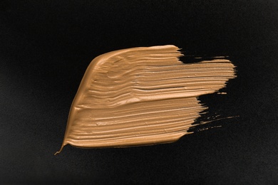 Photo of Golden paint brush strokes on black background