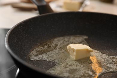 Photo of Frying pan with melted butter on stove, closeup