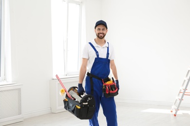 Portrait of professional construction worker with tools indoors