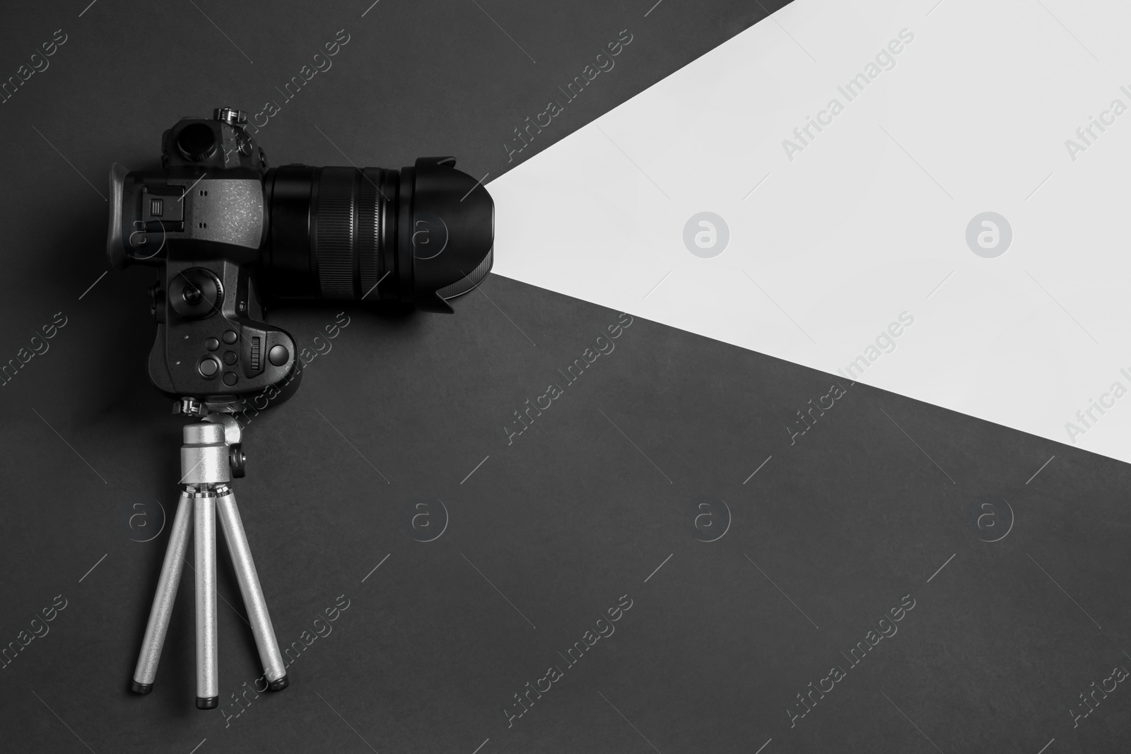 Photo of Modern camera and mini tripod on color background, flat lay with space for text. Video production equipment