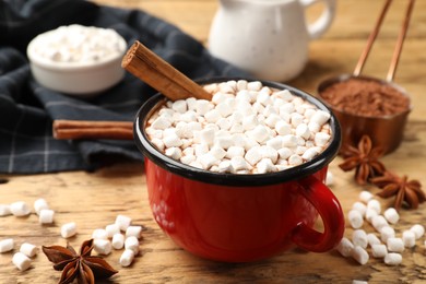 Tasty hot chocolate with marshmallows and ingredients on wooden table, closeup