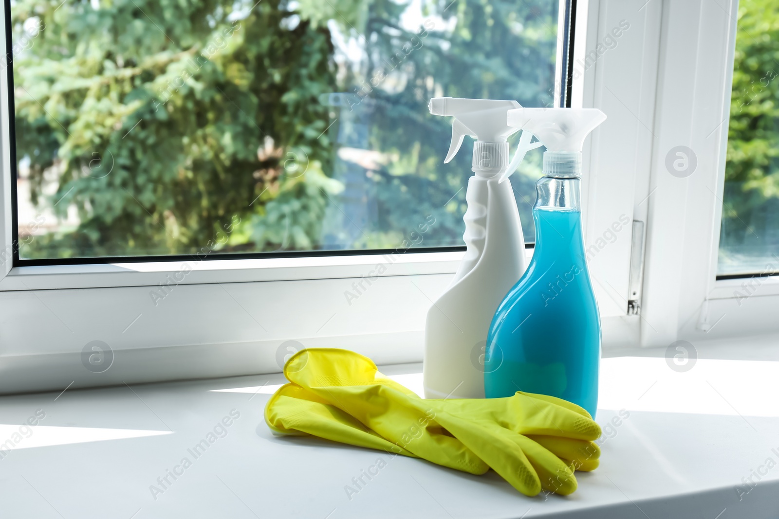 Photo of Spray bottles of detergents and gloves on window sill indoors, space for text. Cleaning supplies