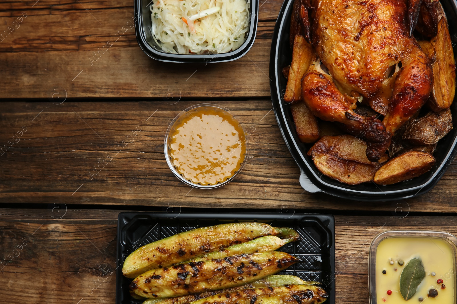 Photo of Plastic containers with different dishes on wooden table, flat lay. Food delivery service