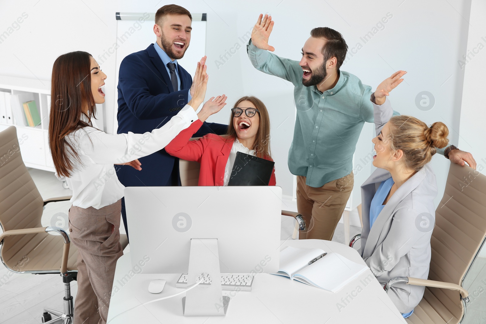 Photo of Group of office employees celebrating victory at workplace