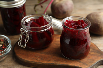 Delicious pickled beets and spices on wooden table