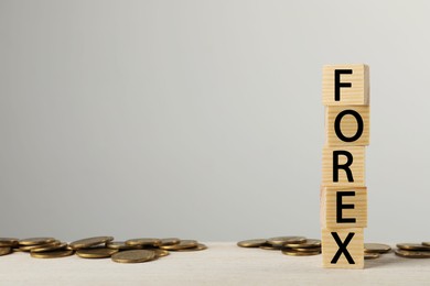 Photo of Word Forex made with wooden cubes and coins on white table